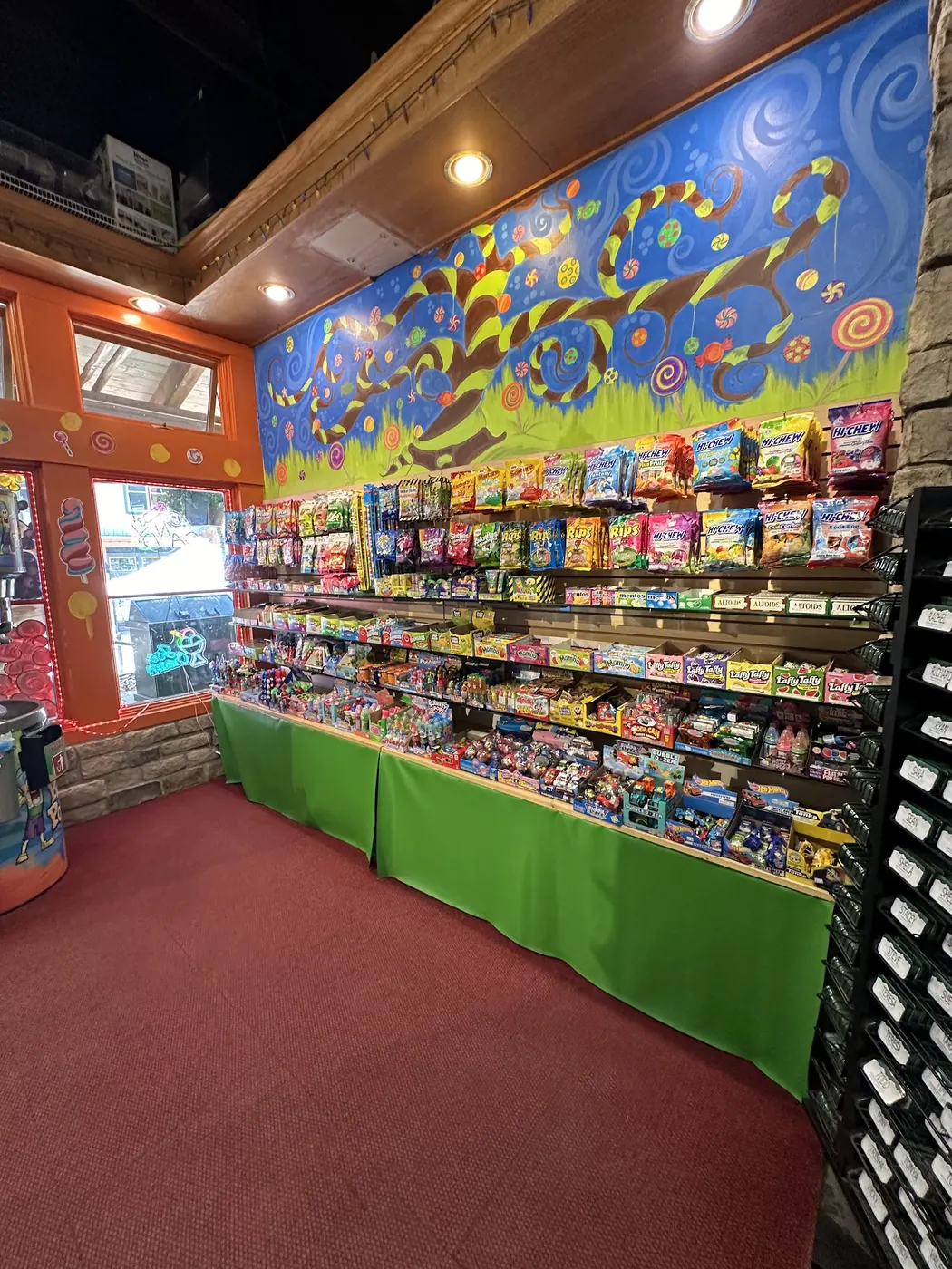 The candy wall under the painted mural, red carpet and green counters