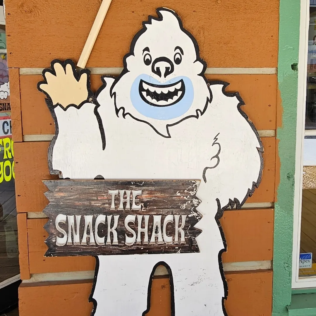 The cardboard yeti holding The Snack Shack sign by the front door